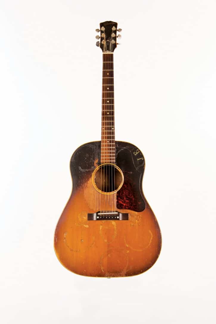 Joe Ely used this Gibson J-45 extensively. He is pictured with it on the cover of his second album, Honky Tonk Masquerade (1978). Ely acquired the guitar from a street musician in Venice, California, who had glued sea shells to the front of the instrument. The finish was damaged when the shells were removed. Courtesy of Joe Ely (Photo Bob Delevante, courtesy Country Music Hall of Fame & Museum)