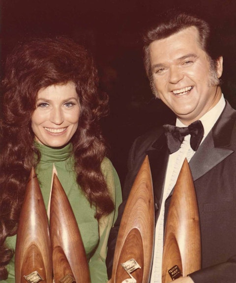 Loretta Lynn and Conway Twitty holding some of their CMA Awards. They won CMA Duo of the Year awards four times running between 1972 and 1975. Photo by Hope Powell.