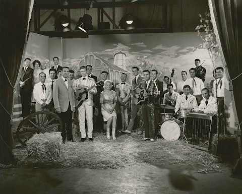 Ralph Emery appeared in the 1967 movie Country Music on Broadway. Here he is with the entire cast. He is on the left, standing next to the wagon wheel. Photo by Joe Horton.