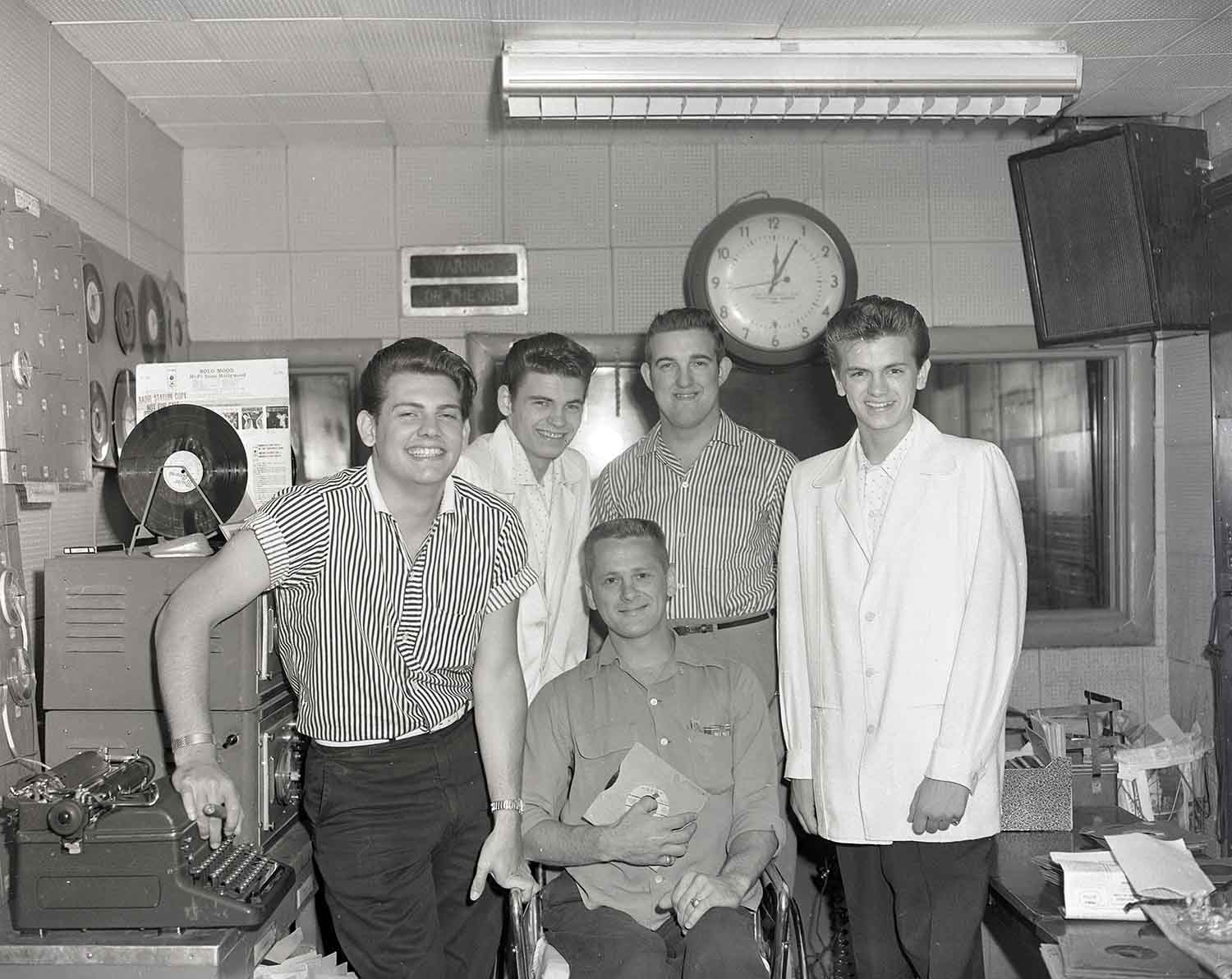 Ralph Emery (standing, center) with the Everly Brothers on either side of him, an unidentified young man standing at left, and disc jockey colleague Bill Morgan (seated) at Nashville radio station WMAK, 1957. Photo by Elmer Williams.