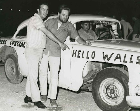 Faron Young and Willie Nelson pose with race car, 1965