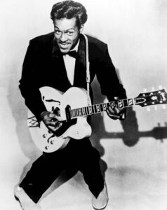Black and White photo of Chuck Berry playing the guitar.