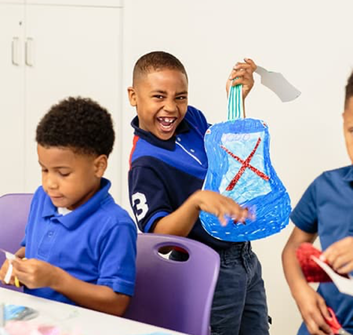 Boy holding a handmade craft guitar