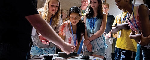 Photo of students at STEAM: Science of Sound at Historic RCA Studio B examining an artifact.