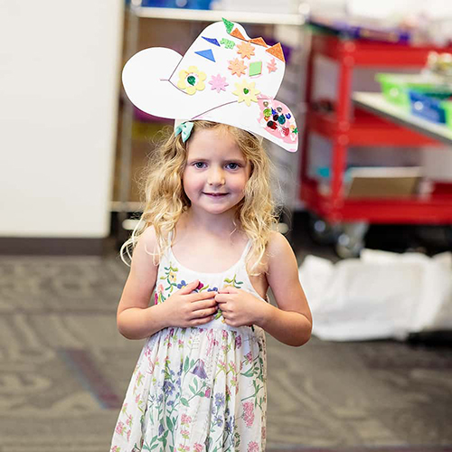 Photo of a child wearing a decorated paper-cutout cowboy hat.