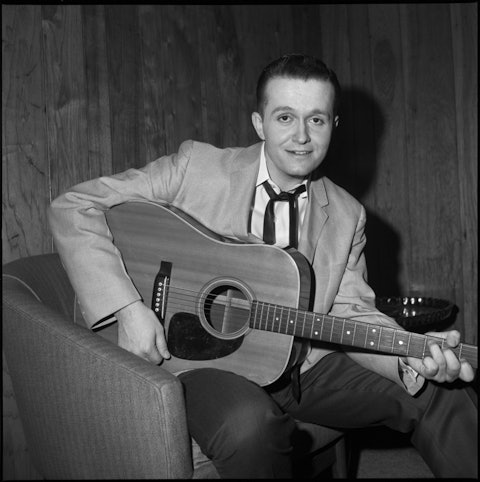 Photo of Bill Anderson playing the guitar in black and white.