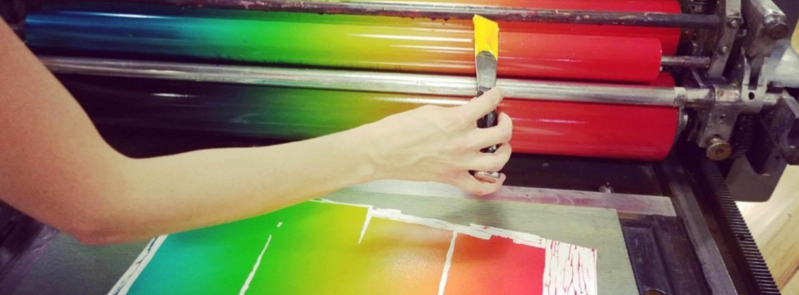 Hatch Show Print Watch & Listen: Get Inky. Photo of someone painting the ink roller with a rainbow gradient.
