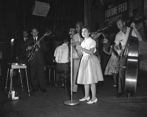 Brenda Lee at the Grand Ole Opry, 1960. Her backing band included Hank Garland on electric guitar (left) and Lightnin’ Chance on standup bass (right). Photo by Elmer Williams