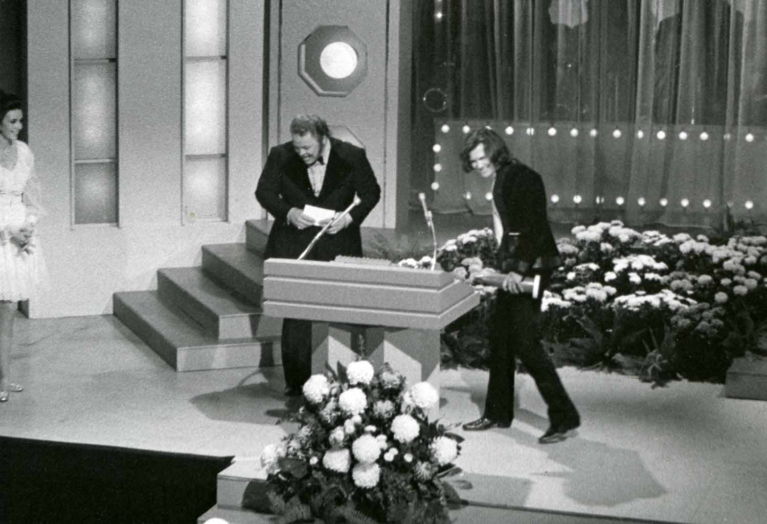 Kris Kristofferson, on stage with Roy Clark, receiving Song of the Year trophy for “Sunday Morning Coming Down” at the 1970 CMA Awards.