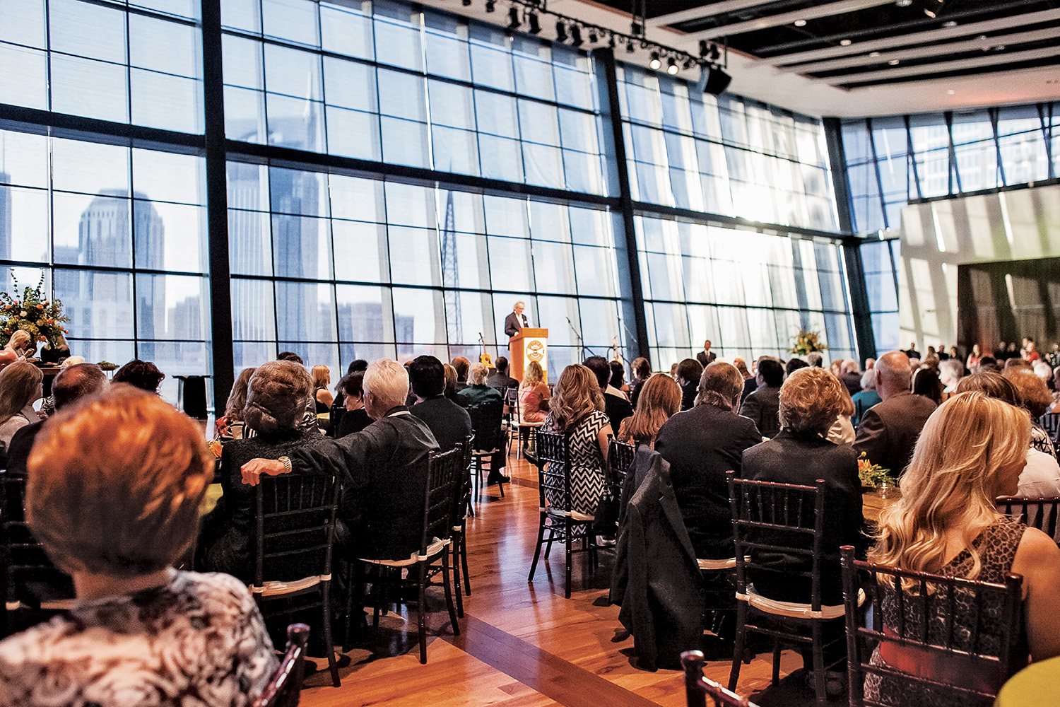 Business man standing at a podium on a stage with guests in attendance sitting at banquet tables at this downtown Nashville Event Spaces.