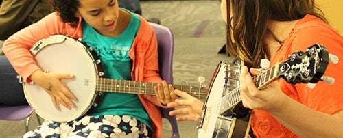 Two girls playing a banjo
