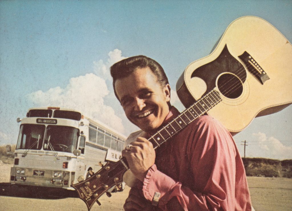 Bill Anderson with a guitar on his shoulder