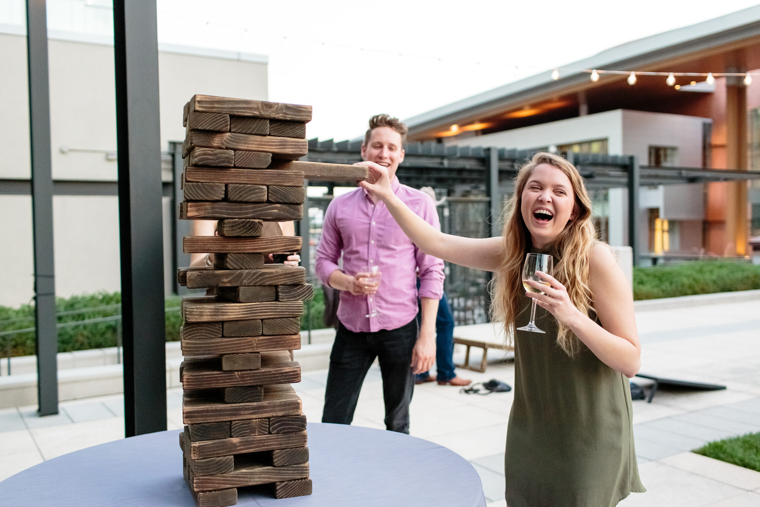 Smiling Happy Troubadour Members play outdoor jenga game during a member event.