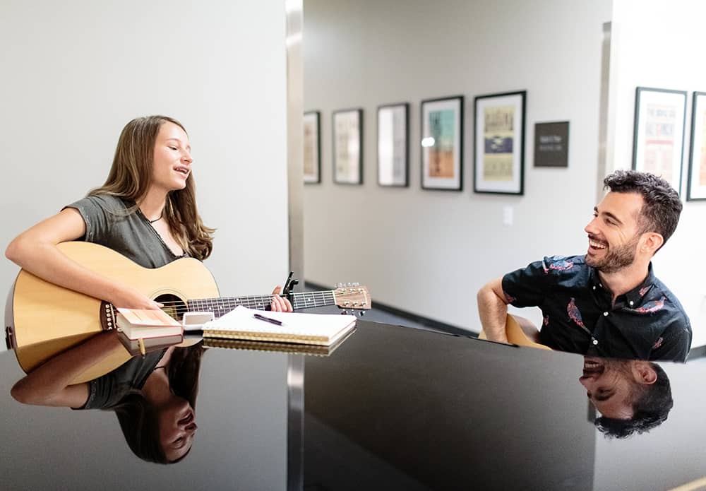 Two people playing a guitar