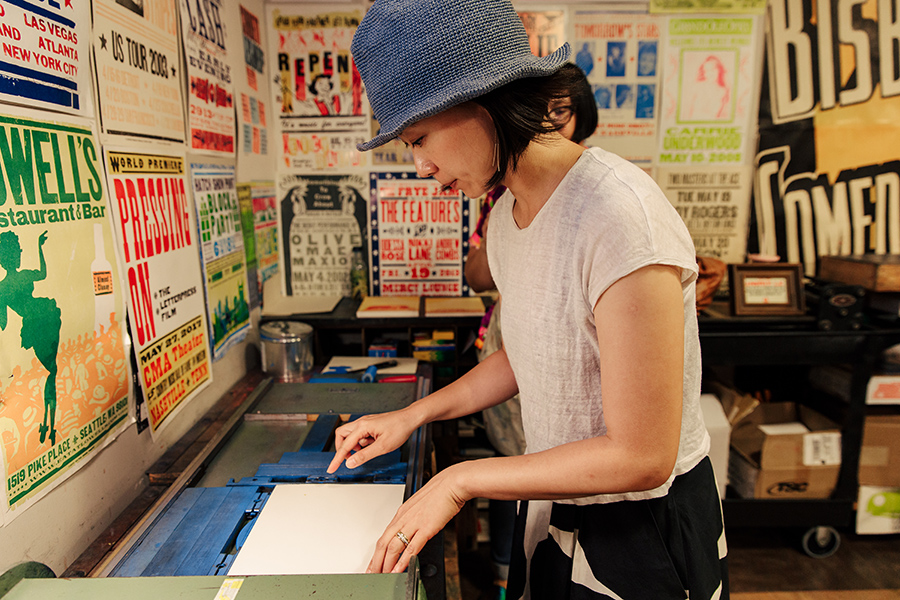 Woman taking the Hatch Show Print Tour makes a print to take home.