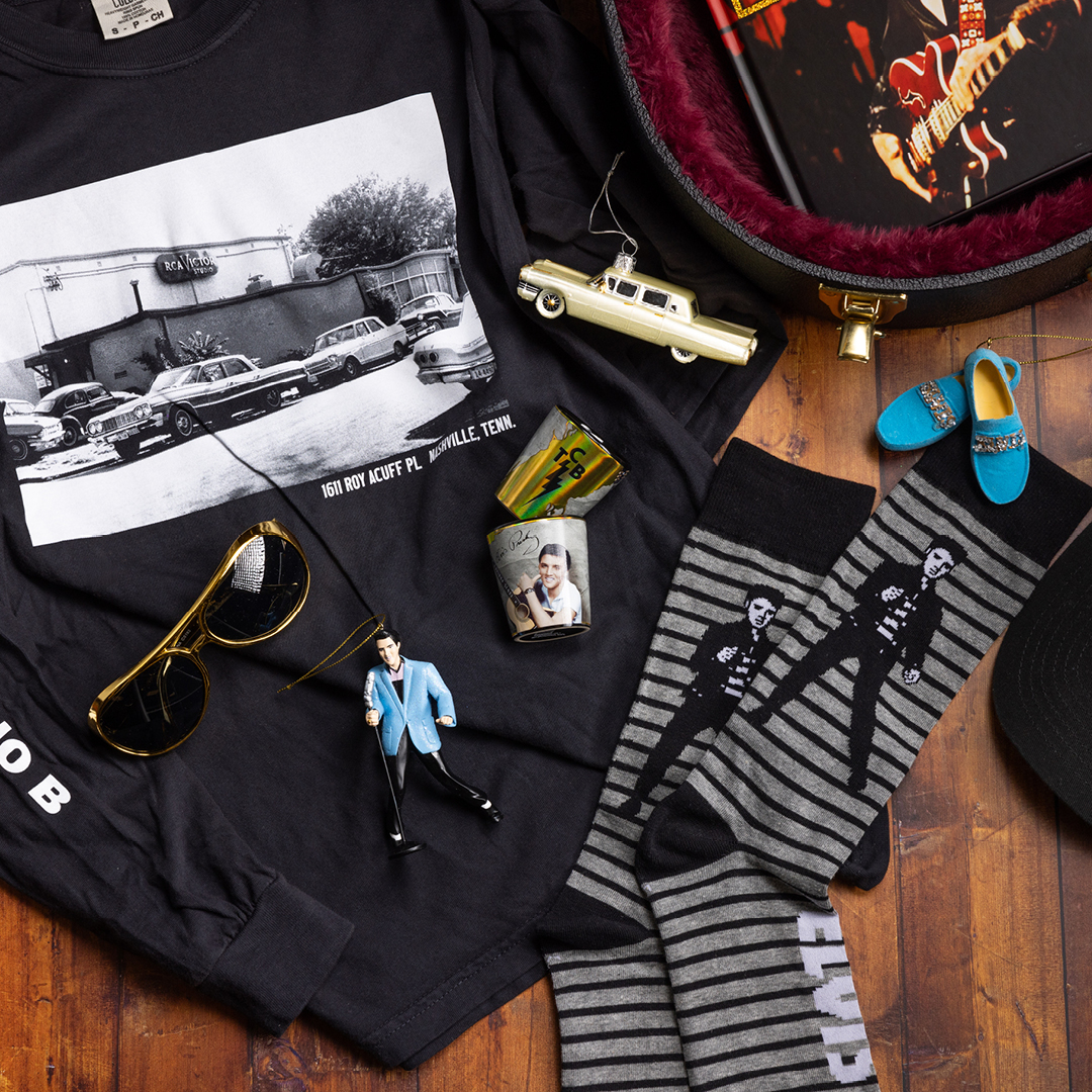 The Elvis Presley Collection at The Museum Store featuring a long sleeve T-shirt, Elvis socks, glasses, ornaments and shot glasses.