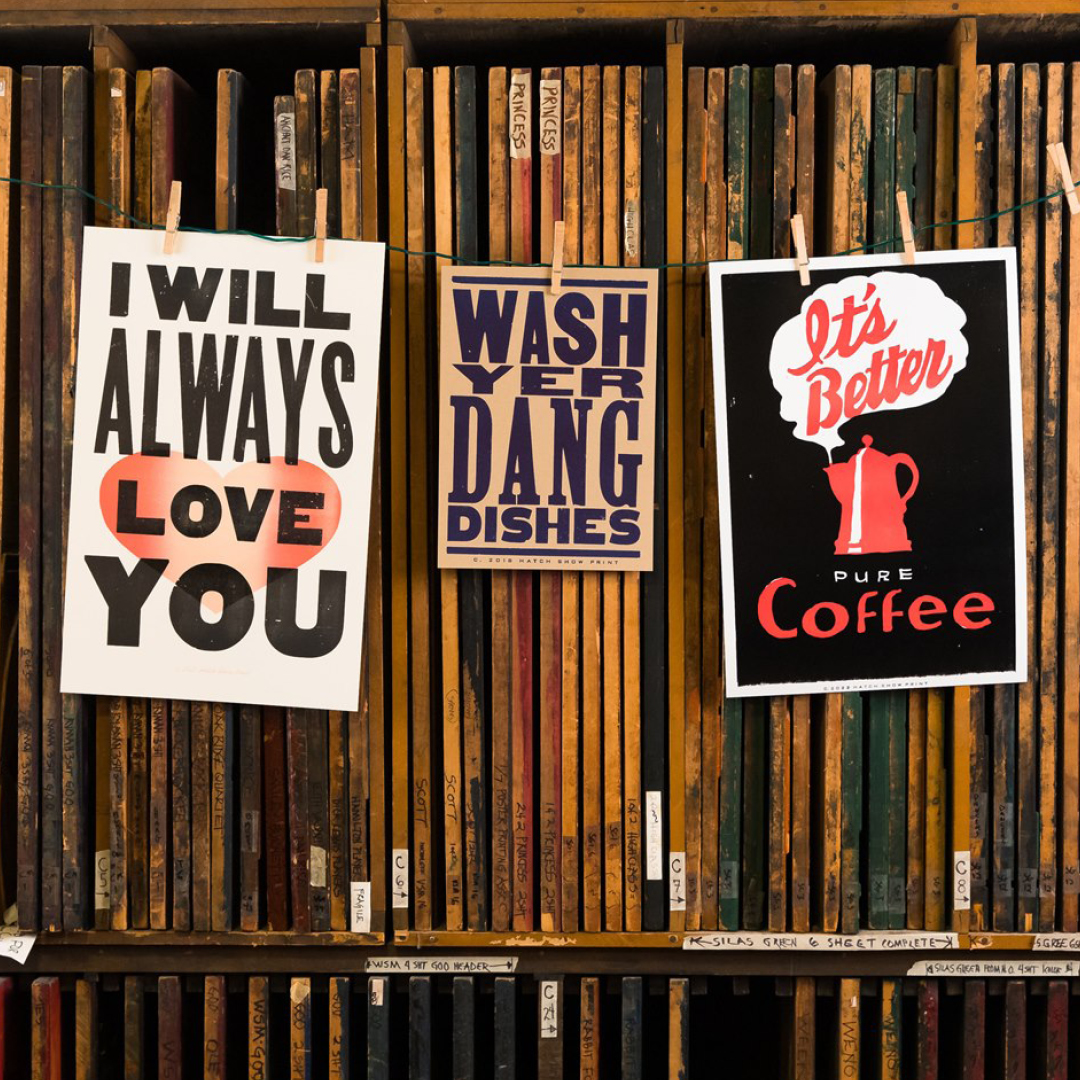 Hatch Show Print Posters hanging against printing blocks.