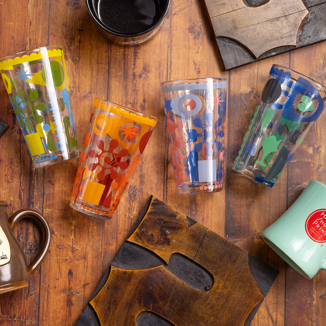 Hatch Show Print Glasses laid out on a table with printing blocks.