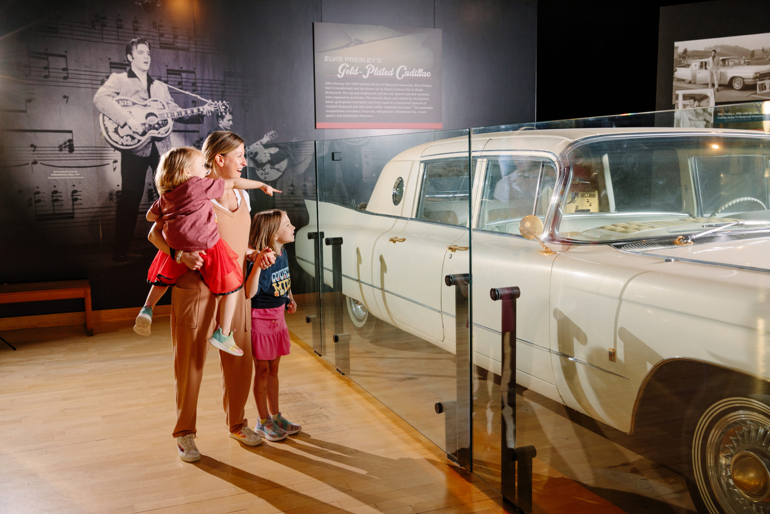 A mother and two daughters looking at one of Elvis Presley's cars